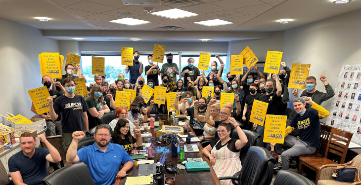 group of people holding strike signs at a table